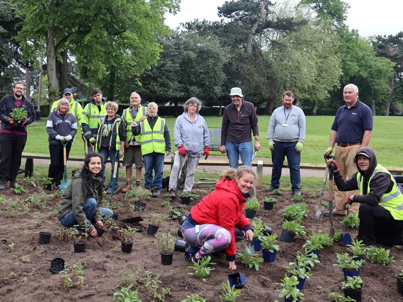 Group of volunteers planting plants in Brinton Park's new pollinator garden