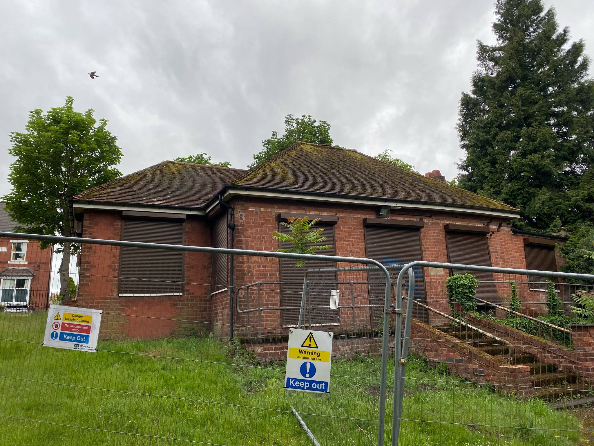 pavilion building surrounded by construction fencing. 